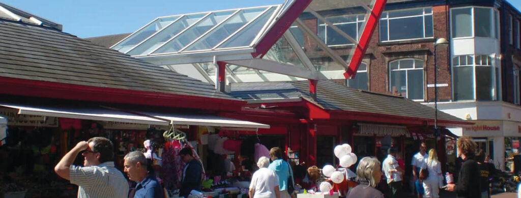 People shopping at outdoor market.