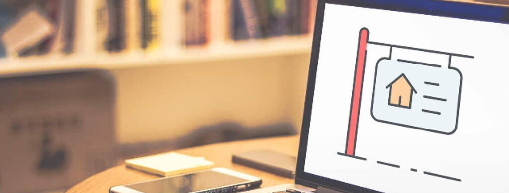 Laptop displaying house icon on desk