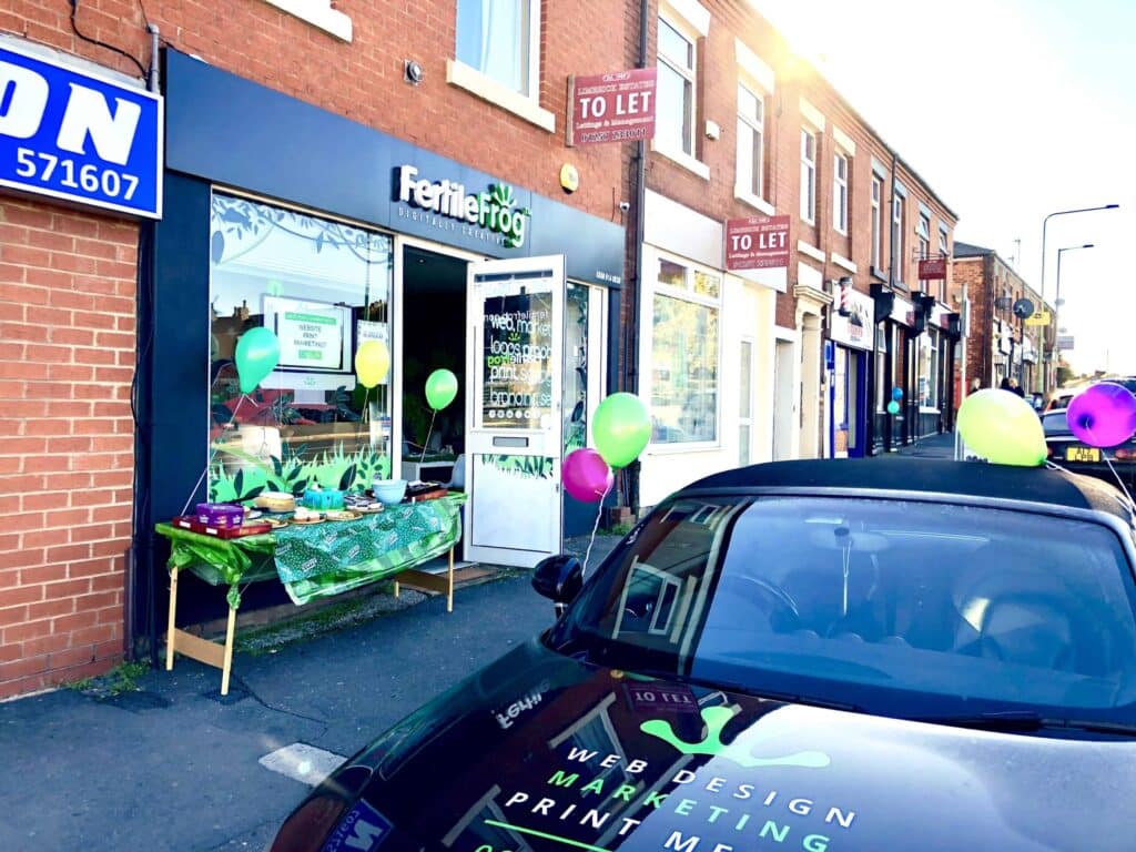 Digital marketing agency storefront with balloons and car.