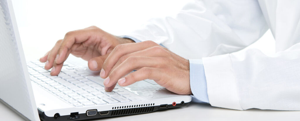 Person typing on white laptop keyboard
