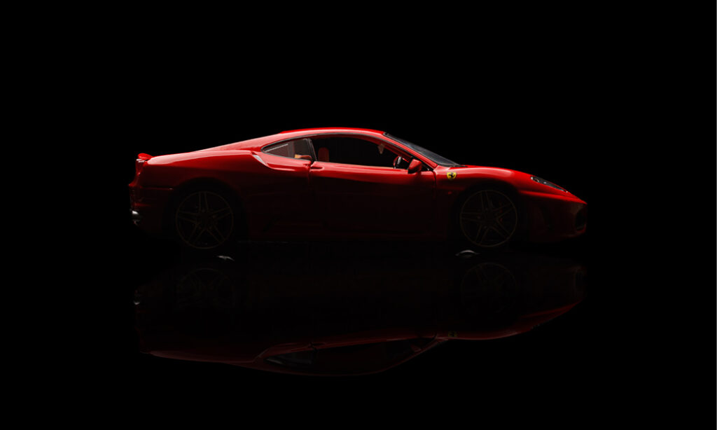 Red sports car on reflective surface