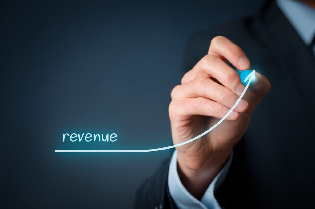 Hand drawing upward revenue growth arrow.