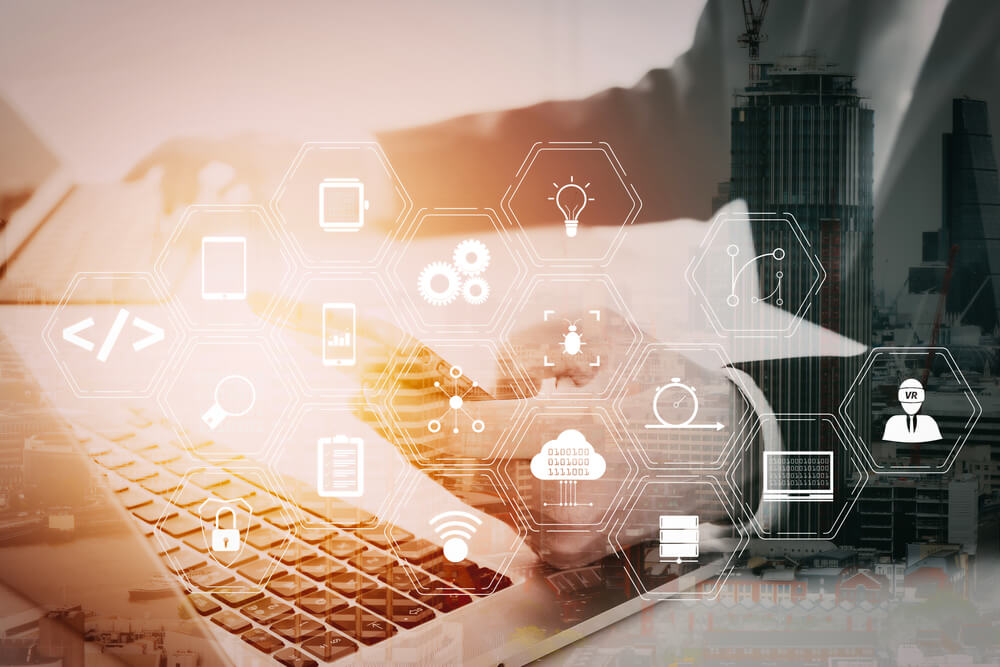 Person using laptop with digital icons overlay.