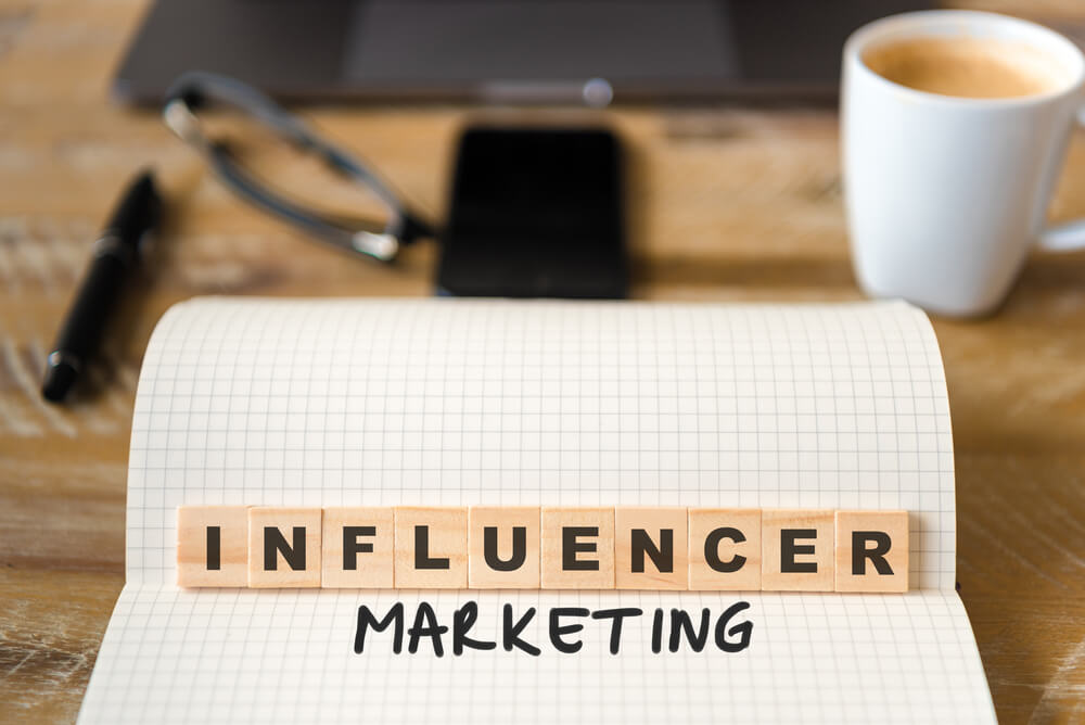 Influencer marketing concept with coffee and notepad