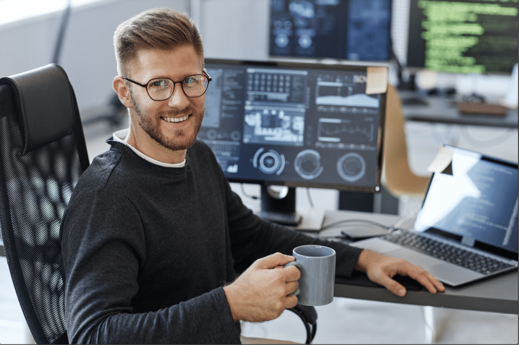 Man with glasses working at computer station.