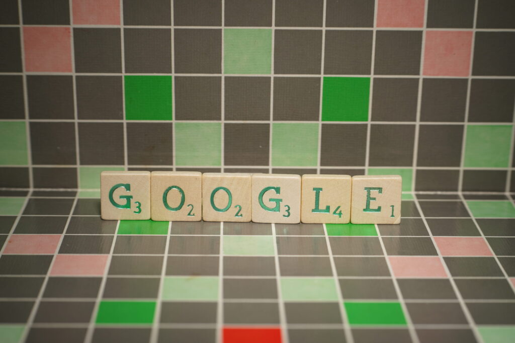 Scrabble tiles spell Google on colourful board.