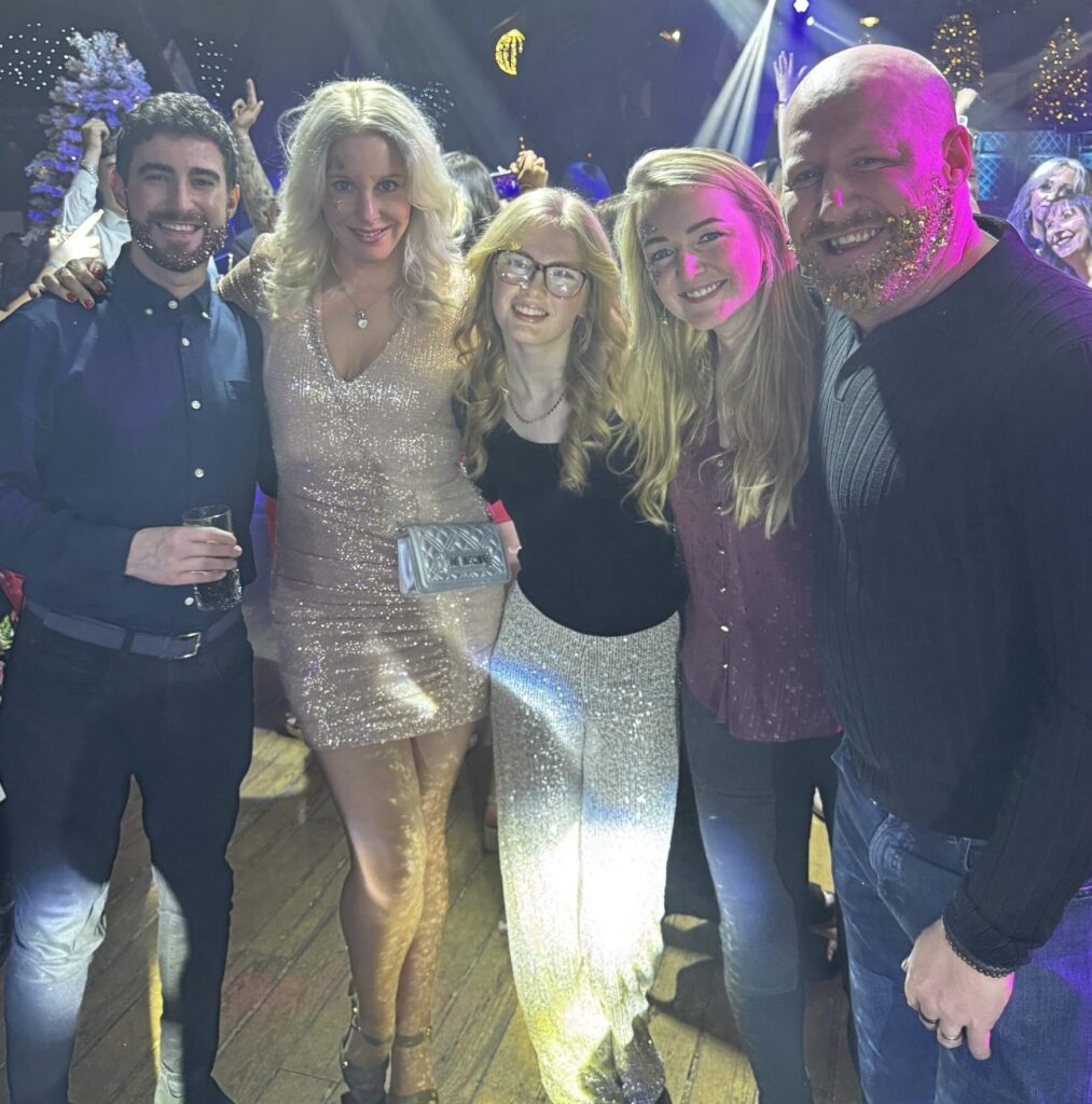 Group of five people at a colourful party.