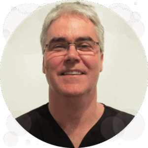 Smiling man with glasses, light background