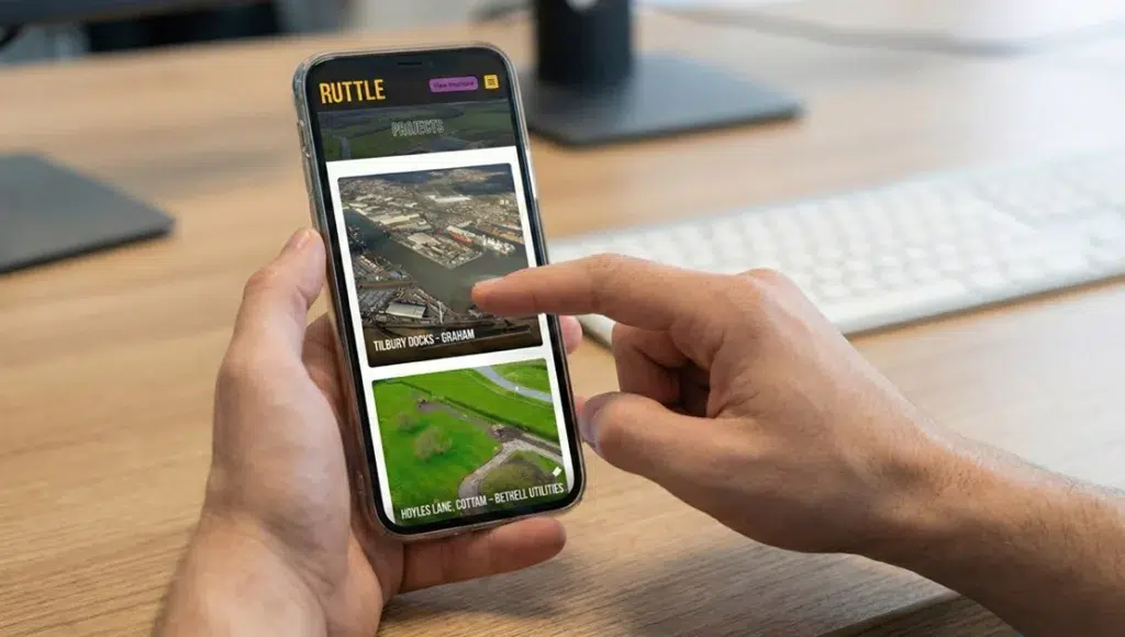 Hand interacting with construction project app on phone.