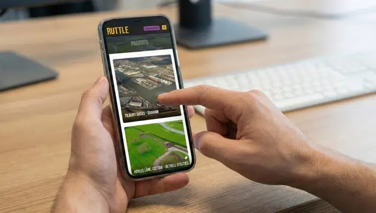 Hand interacting with construction project app on phone.