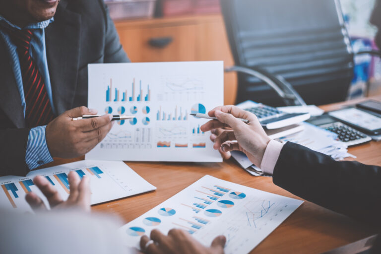 Business meeting analysing financial graphs and charts.