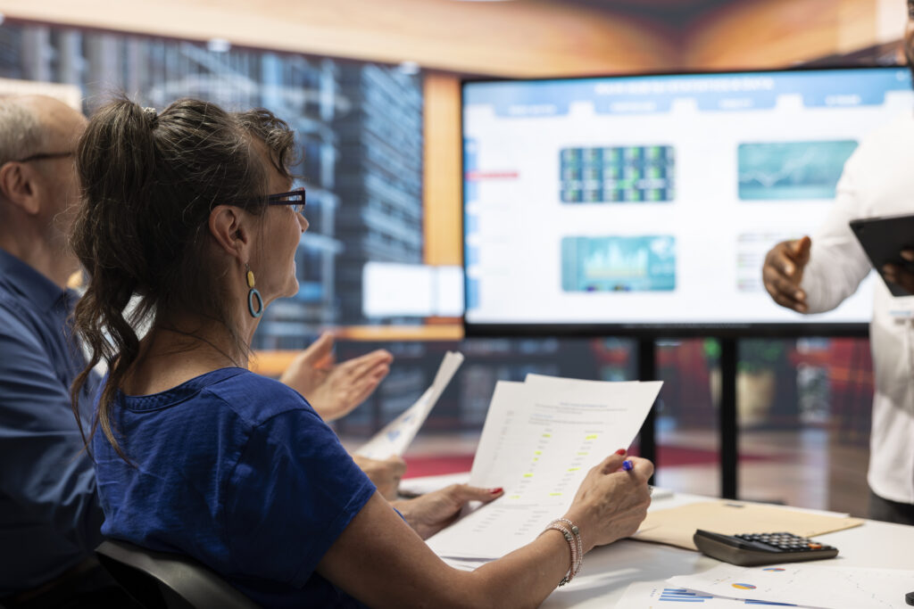 Team analysing data on screen with documents