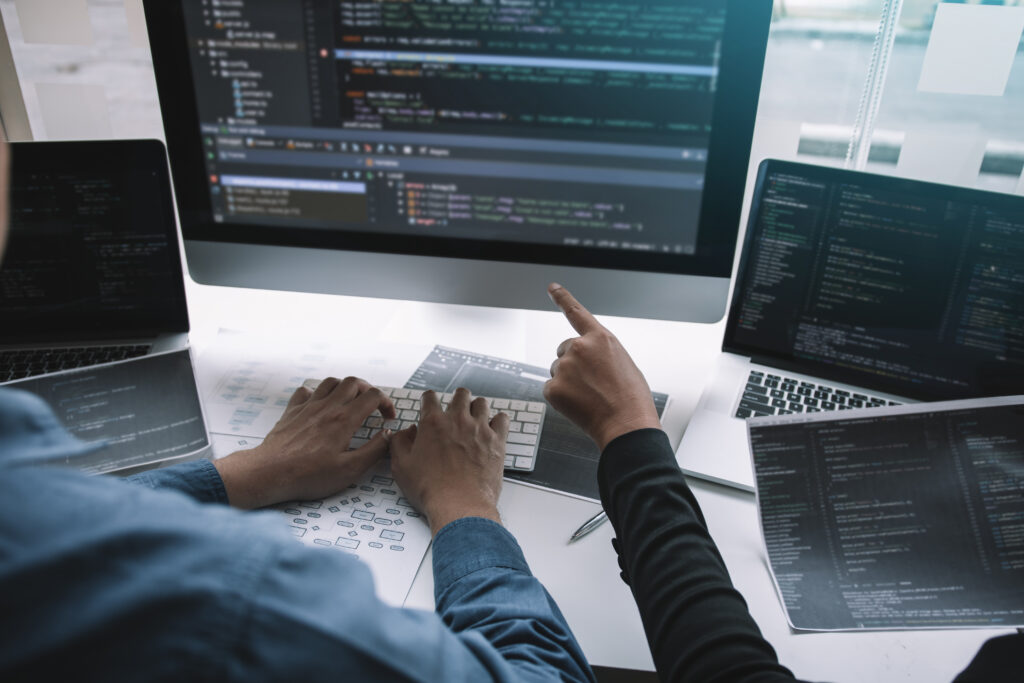 Developers collaborating on computer coding project.