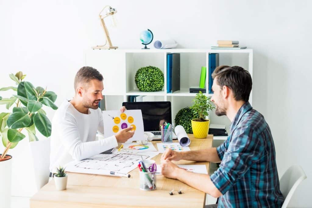 Two men discussing business project in modern office.